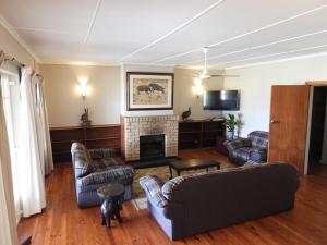 sala de estar con 2 sofás y chimenea en The Ranch House at African Safari Lodge, en Grahamstown