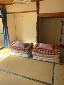 two ottomans sitting on the floor in a room at Guest House Iwato in Takachiho