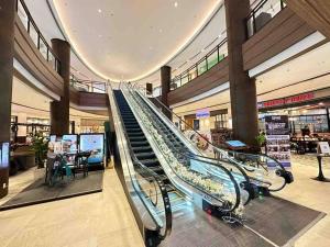 a escalator in a shopping mall with a staircase at Modern Classic 1 BR Condo Air Residences Makati in Manila