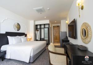 um quarto com uma grande cama branca e uma secretária em PHÚ YÊN EVERYDAY HOTEL em Tuy Hoa