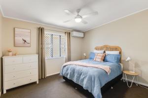 1 dormitorio con 1 cama, vestidor y ventana en Light & Bright! 3 Bedroom Cottage, East Toowoomba!, en Toowoomba