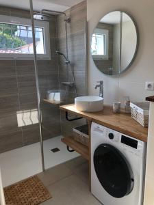 ein Badezimmer mit einer Waschmaschine und einem Spiegel in der Unterkunft Maison au cœur de la La Palmyre in Les Mathes