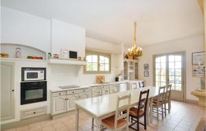 uma cozinha branca com uma mesa e cadeiras em Awesome Home In Bziers With 7 Bedrooms, Private Swimming Pool And Swimming Pool em Montblanc