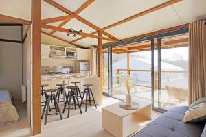 a kitchen and living room in a house with glass doors at Ushuaïa Villages La Buissonnière Lodges in Chisseaux