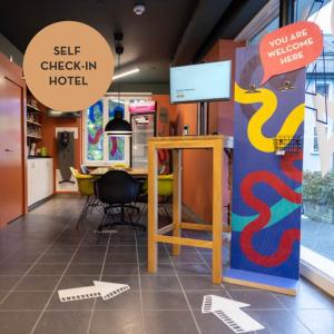 een kamer met een bureau en een bord waarop staat: zelf inchecken in het hotel bij Self Check-In Hotel David 22 in St. Gallen