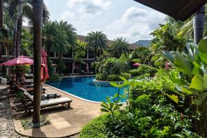 una piscina en un complejo con palmeras en Am Samui Palace, en Lamai