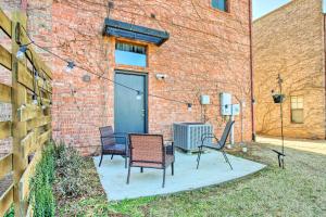 eine Terrasse mit Stühlen und einem Tisch vor einem Backsteingebäude in der Unterkunft Norman, Oklahoma, Vacation Rental 1 Mi to OU! in Norman