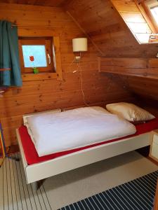 a bed in a log cabin with a window at Laras Ferienhaus in Worpswede