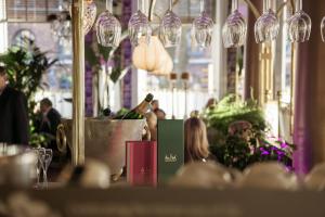 a table with wine glasses and people in a restaurant at Continental du Sud in Ystad