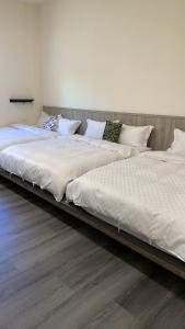 - 2 lits installés l'un à côté de l'autre dans une chambre dans l'établissement 阿里山-山日茶旅民宿, à Le-yeh