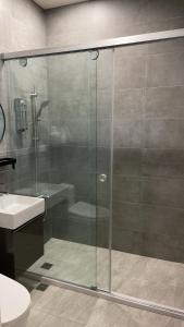 La salle de bains est pourvue d'une douche en verre et d'un lavabo. dans l'établissement 阿里山-山日茶旅民宿, à Le-yeh