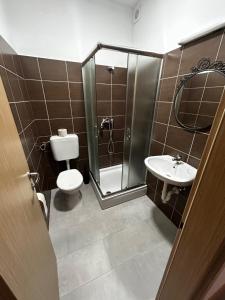 a bathroom with a shower and a toilet and a sink at Sobe Zimmer Frei in Požega