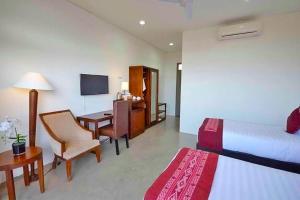 a hotel room with a bedroom with two beds and a desk at Balibo Fort Hotel in Balibo