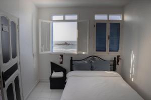 a bedroom with a bed with a view of the ocean at Auberge Sable D'Or in Sidi Ifni