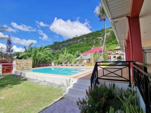 a resort with a swimming pool and a mountain at SBG Resort Lambug in Badian