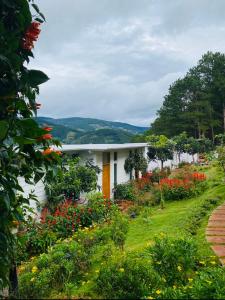 a white house with a garden with flowers at Nacasoo hill in Tiên Hai