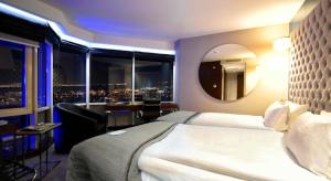 a hotel room with a bed and a view of a city at Ramada Encore by Wyndham Izmir in İzmir