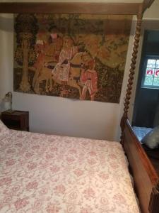 una camera da letto con un letto e un dipinto sul muro di Villa Normandy a Gagny