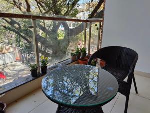 a glass table and chairs in front of a window at Tara Suites Premium rooms in Central Indiranagar in Bengaluru