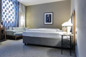 Hotel George Vienna في فيينا: غرفة نوم بسرير كبير وكرسي