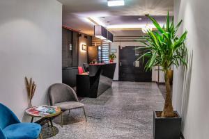 eine Lobby mit einem Wartebereich mit Stühlen und Pflanzen in der Unterkunft Hotel George Vienna in Wien
