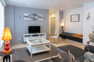 a living room with a couch and a tv at Le Rooftop Briviste - 2 Chambres in Brive-la-Gaillarde