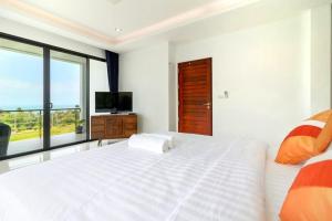a bedroom with a large white bed and a television at Sea VIEW POOL Villa - 8 peoples- Private Pool - Beautiful garden in Ban Bang Po