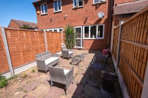 a patio with chairs and a table and a fence at I Love London! A STUNNING 2Bed Home Sleeps 1-4! in Thamesmead