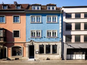 un bâtiment bleu avec des fenêtres blanches sur une rue dans l'établissement Hotel Kunterbunt - by homekeepers, à Wurtzbourg