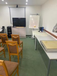 a room with tables and chairs and a projection screen at Hotel SEVERKA in Zákopčie