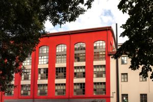 un bâtiment rouge avec des fenêtres latérales dans l'établissement Residence 2Gi, à Milan