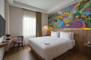 une chambre d'hôtel avec un grand lit et un tableau mural dans l'établissement MaxOneHotels at Kota Harapan Indah-Bekasi, à Bekasi 26 autres photos