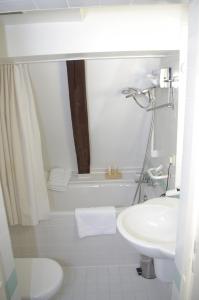 ein weißes Bad mit einem Waschbecken und einem WC in der Unterkunft Altes Badhaus in Eberbach