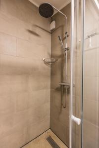a shower with a glass door and a shower head at Nieuw Holiday home Oostkapelle centrum in Oostkapelle