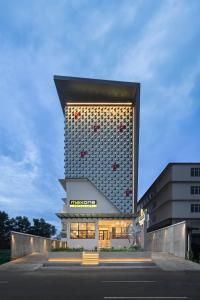 un gran edificio con una fachada iluminada en MaxOneHotels at Kota Harapan Indah-Bekasi en Bekasi