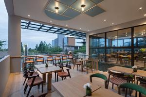 un restaurante con mesas y sillas en un balcón en MaxOneHotels at Kota Harapan Indah-Bekasi en Bekasi