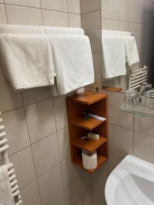 a bathroom with white towels and a sink and a mirror at Hotel Hunor in Sátoraljaújhely