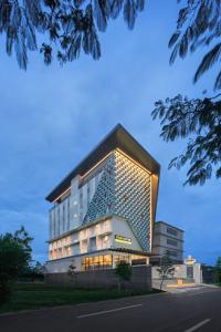un gran edificio con luces en el lateral en MaxOneHotels at Kota Harapan Indah-Bekasi en Bekasi