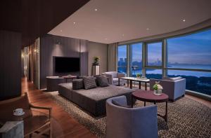 a living room with a couch and chairs and a television at Andaz Shenzhen Bay in Shenzhen