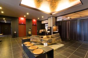 a lobby with a pile of logs and stools at Dormy Inn Premium Kyoto Ekimae Natural Hot Spring in Kyoto