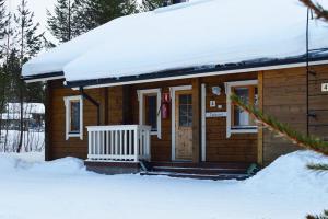 una piccola cabina in legno con neve sul tetto di Turkoosi a Vuokatti