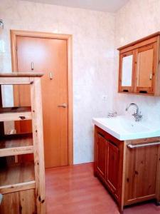 a kitchen with a sink and a wooden cabinet at Precioso atico con bonitas vistas a la Peña Oroel in Jaca
