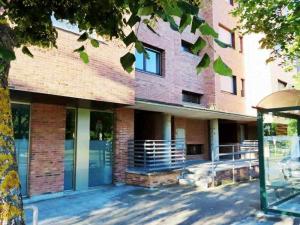 a large brick building with a gate in front of it at Precioso atico con bonitas vistas a la Peña Oroel in Jaca