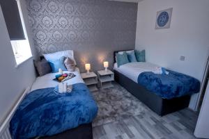 1 dormitorio con 2 camas con colchas azules y velas en I Love London! A STUNNING 2Bed Home Sleeps 1-4! en Thamesmead