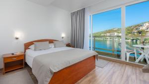 a hotel room with a bed and a large window at Hotel Vis in Dubrovnik