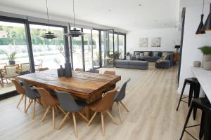 comedor y sala de estar con mesa de madera y sillas en VILLA SP SUITES SANTA PONSA, en Santa Ponsa