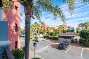 a palm tree in a parking lot next to a building at El Rincón del Golf I by Ĥ - Isla Canela Golf GRHI6P06 in Isla Canela