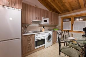 a kitchen with a white refrigerator and a dishwasher at El Busque Casa Rural in Casla