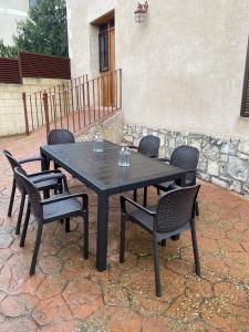 una mesa negra y sillas en un patio en El Busque Casa Rural, en Casla