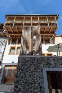 a building with a wooden gate on the side of it at Albergo Diffuso Dolomiti in Forni di Sotto